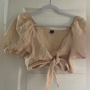 beige crop top, tied in middle with a bow